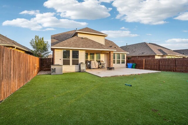 rear view of property featuring a patio area and a yard