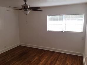 spare room featuring ceiling fan and dark wood-type flooring