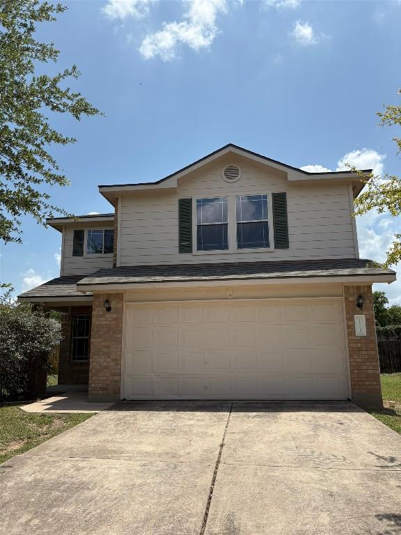 173 Ruby Lake Dr, Kyle, TX 78640 - traditional-style home featuring a garage, driveway, and brick siding