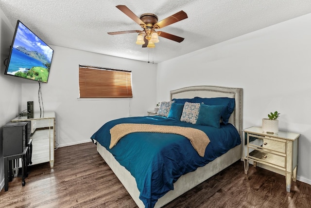 bedroom with a textured ceiling, ceiling fan, and dark wood-type flooring