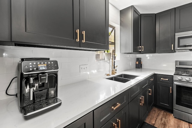 kitchen featuring backsplash, dark hardwood / wood-style floors, sink, and appliances with stainless steel finishes