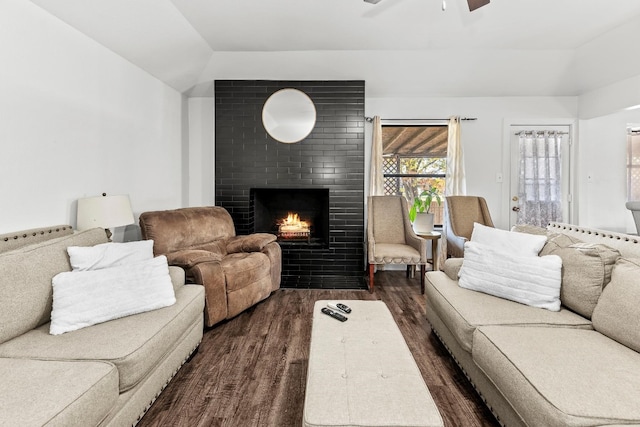 living room featuring ceiling fan, a fireplace, dark wood-type flooring, and vaulted ceiling