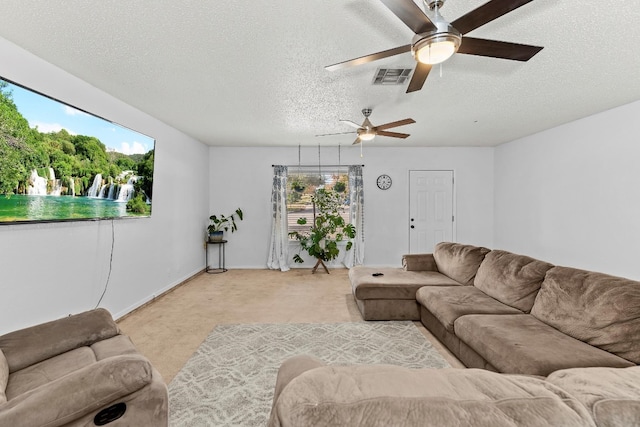 living room featuring ceiling fan, light colored carpet, and a textured ceiling