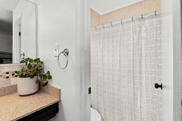 bathroom with vanity, toilet, a textured ceiling, and walk in shower