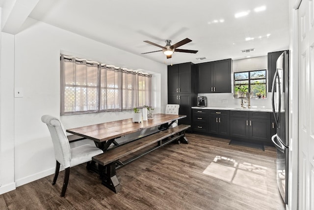 dining room with wood-type flooring, ceiling fan, and sink