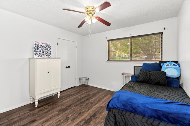 bedroom with ceiling fan, dark hardwood / wood-style floors, and a textured ceiling