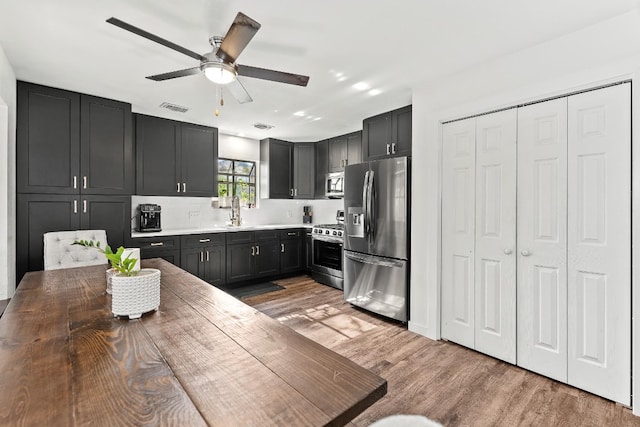 kitchen with hardwood / wood-style flooring, sink, ceiling fan, and appliances with stainless steel finishes