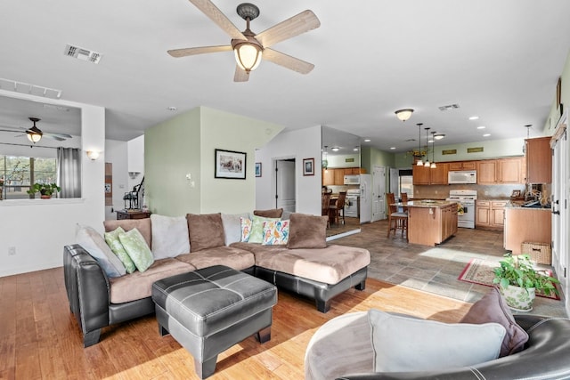 living room with light wood-style flooring and visible vents