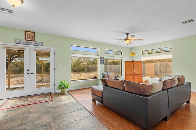 living room with ceiling fan, visible vents, baseboards, and french doors