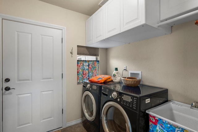 laundry room featuring washing machine and clothes dryer, a sink, cabinet space, and baseboards