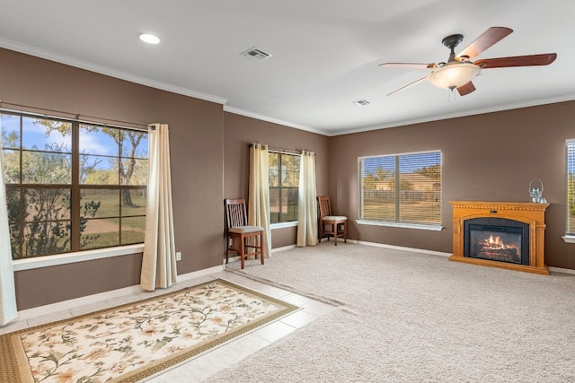 sitting room featuring ornamental molding, a glass covered fireplace, visible vents, and baseboards