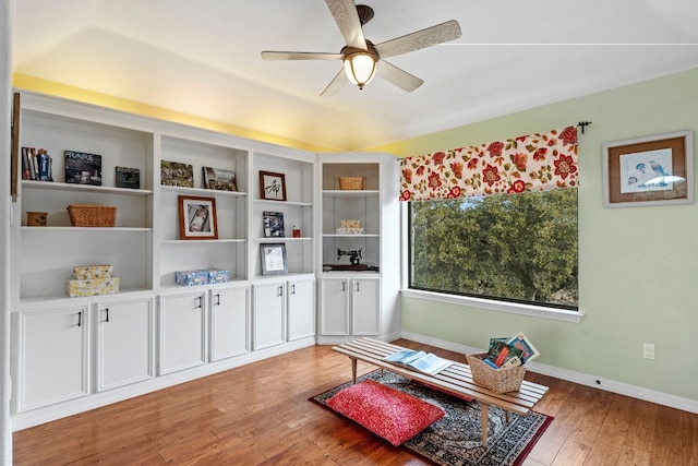 living area featuring ceiling fan, light wood-style flooring, and baseboards