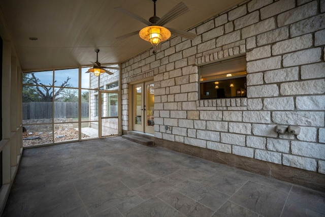 unfurnished sunroom featuring ceiling fan