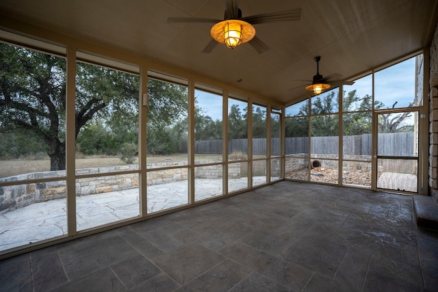 unfurnished sunroom with ceiling fan