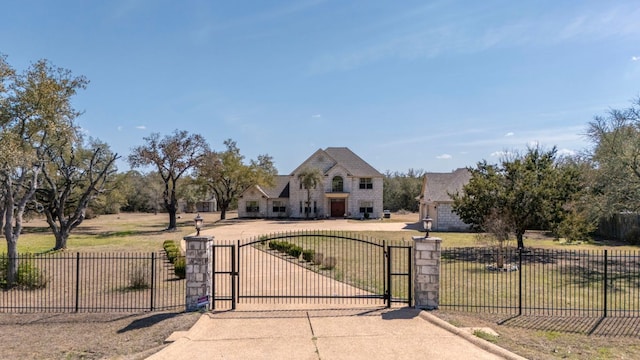 french country inspired facade featuring a gate, fence, and a front yard