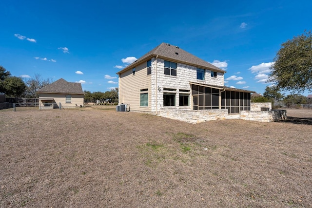 back of property with a sunroom, central AC, and a yard