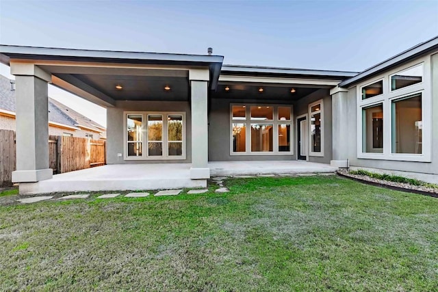 rear view of property featuring a lawn and a patio