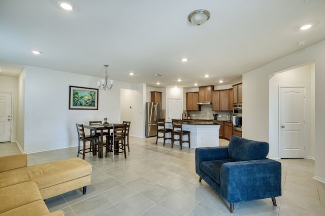 tiled living room with a notable chandelier and sink