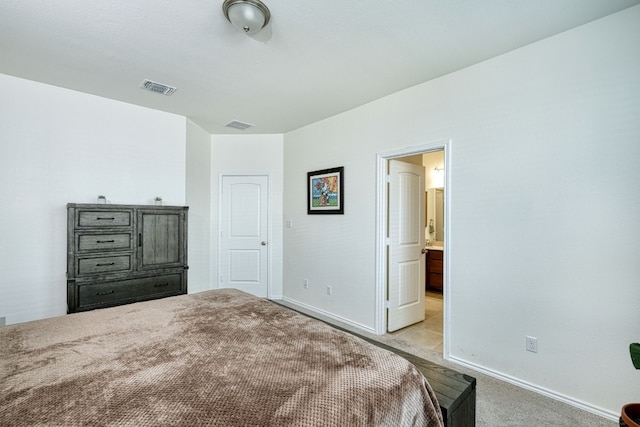 bedroom featuring light carpet and ensuite bath