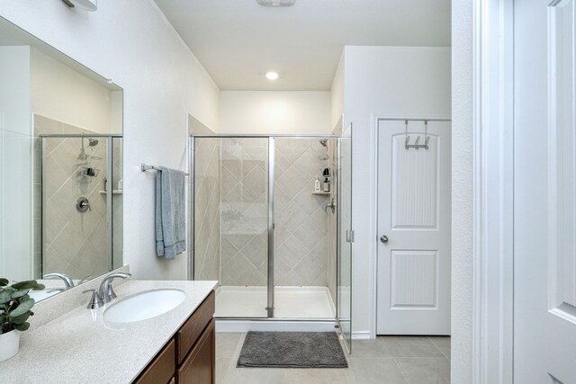 bathroom with tile patterned flooring, vanity, and an enclosed shower