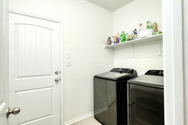 laundry area with washer and clothes dryer and light tile patterned flooring