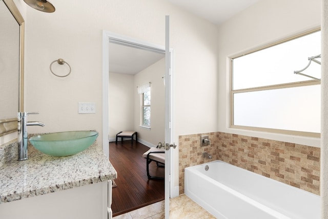 bathroom featuring vanity, hardwood / wood-style flooring, and a tub