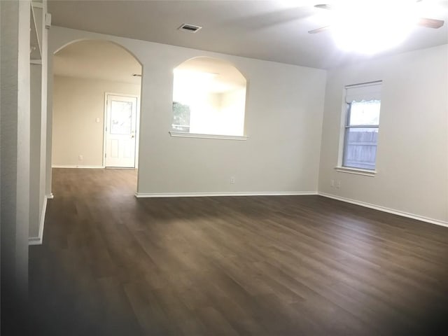 empty room with dark hardwood / wood-style floors and ceiling fan