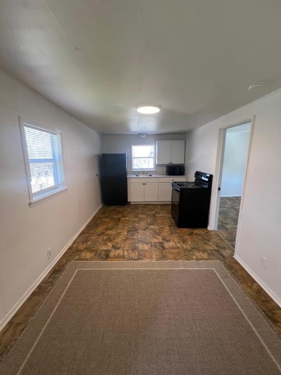 kitchen with white cabinets, sink, and black appliances