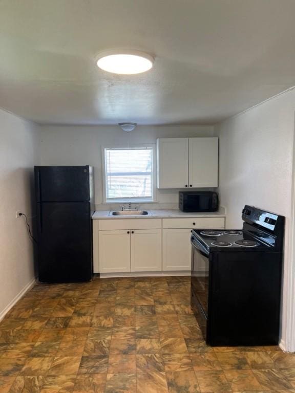 kitchen featuring sink, white cabinets, and black appliances