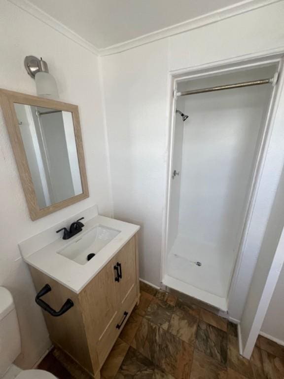 bathroom featuring a shower, toilet, ornamental molding, and sink