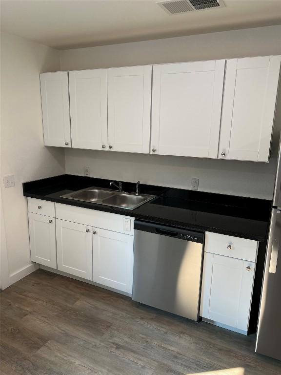 kitchen featuring dishwasher, dark hardwood / wood-style flooring, white cabinets, and sink