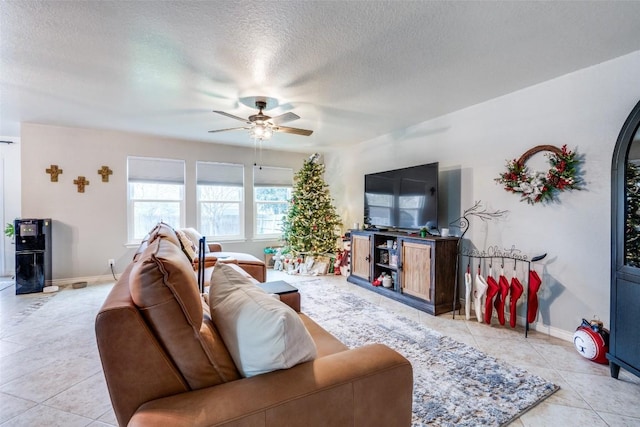 tiled living room with ceiling fan and a textured ceiling