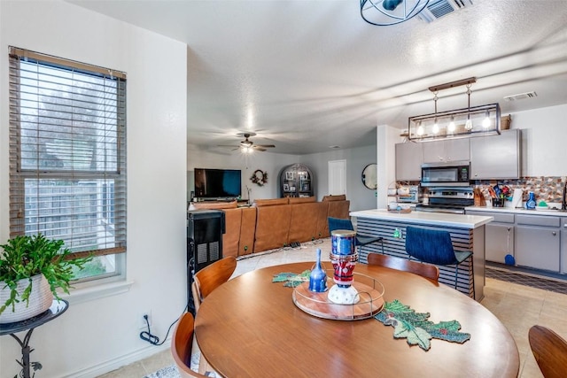 tiled dining room featuring ceiling fan and a healthy amount of sunlight