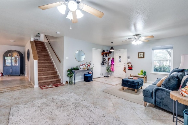 living room with ceiling fan and a textured ceiling