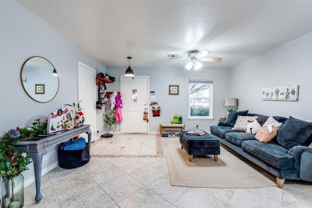 living room with light tile patterned floors, a textured ceiling, and ceiling fan