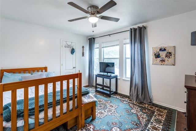 bedroom with ceiling fan and dark hardwood / wood-style floors