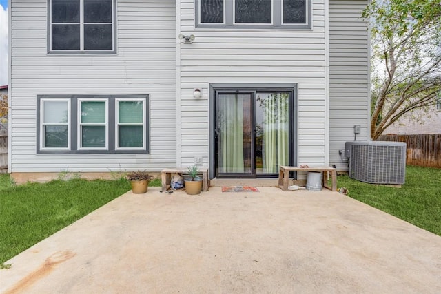 rear view of property with a lawn, a patio, and central AC