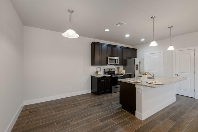 kitchen with hanging light fixtures, dark hardwood / wood-style flooring, stainless steel appliances, and a center island with sink