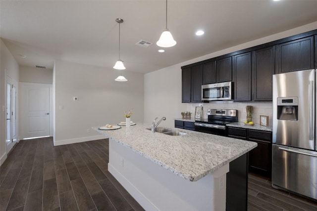 kitchen featuring hanging light fixtures, a center island with sink, stainless steel appliances, and sink