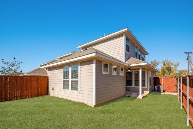 back of property with a lawn and central air condition unit