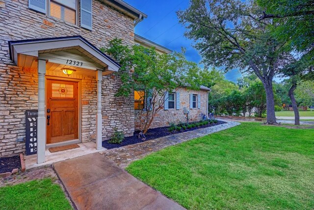 12323 Blue Water Dr, Austin, TX 78758 - entrance to property with stone siding and a yard