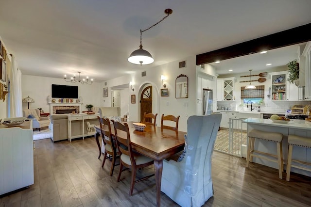 12323 Blue Water Dr, Austin, TX 78758 - dining room with a chandelier, dark wood-style floors, beam ceiling, a fireplace, and recessed lighting