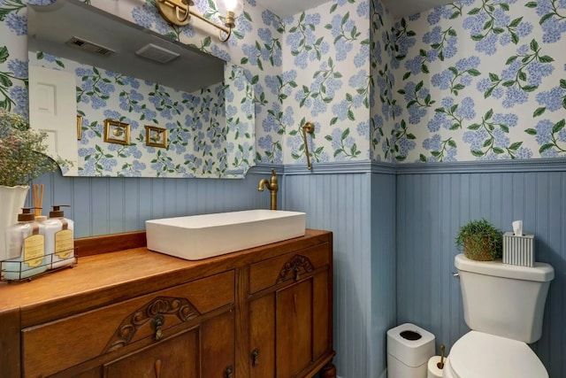 12323 Blue Water Dr, Austin, TX 78758 - bathroom with wallpapered walls, wainscoting, and vanity