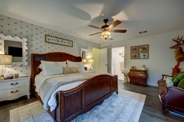 12323 Blue Water Dr, Austin, TX 78758 - bedroom with wallpapered walls, dark wood-style floors, a ceiling fan, and connected bathroom