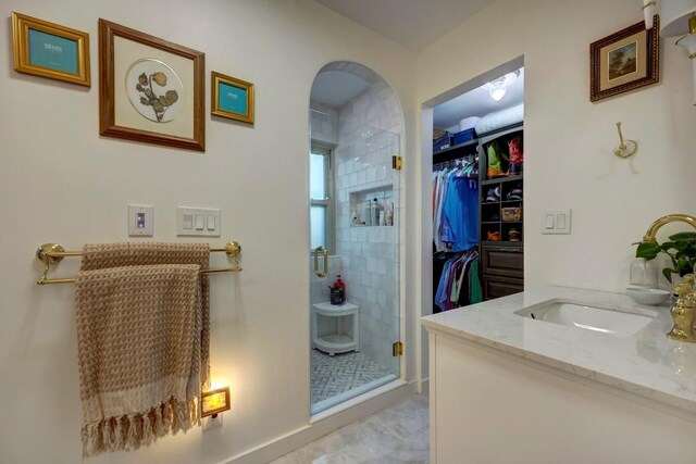 bathroom featuring tile patterned flooring, vanity, and walk in shower