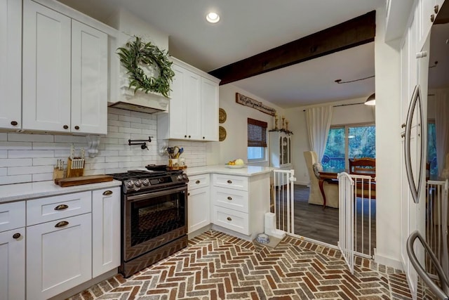 kitchen with white cabinets, beam ceiling, tasteful backsplash, gas stove, and kitchen peninsula