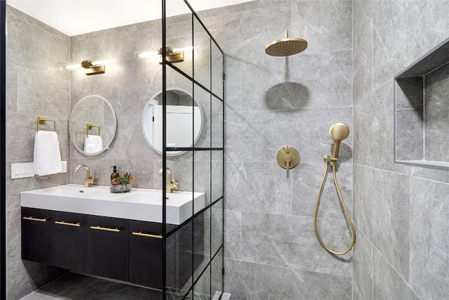 bathroom featuring tiled shower, vanity, and tile walls