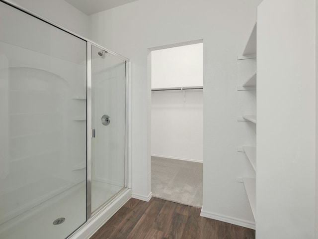 bathroom with a shower with door and wood-type flooring