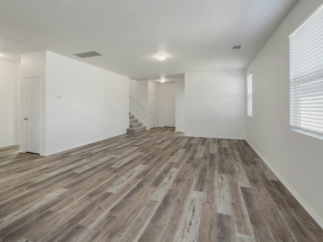 unfurnished living room featuring dark hardwood / wood-style floors and a textured ceiling