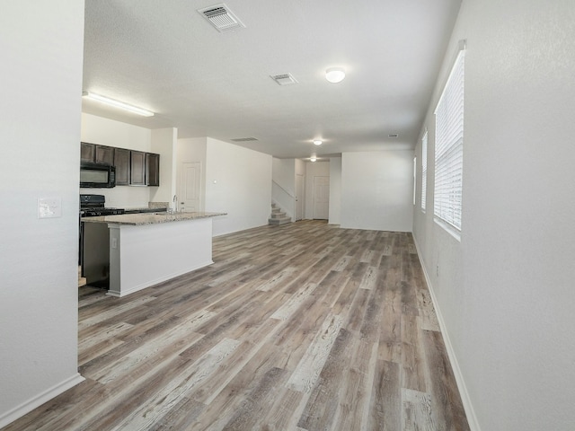 unfurnished living room with a textured ceiling and light wood-type flooring